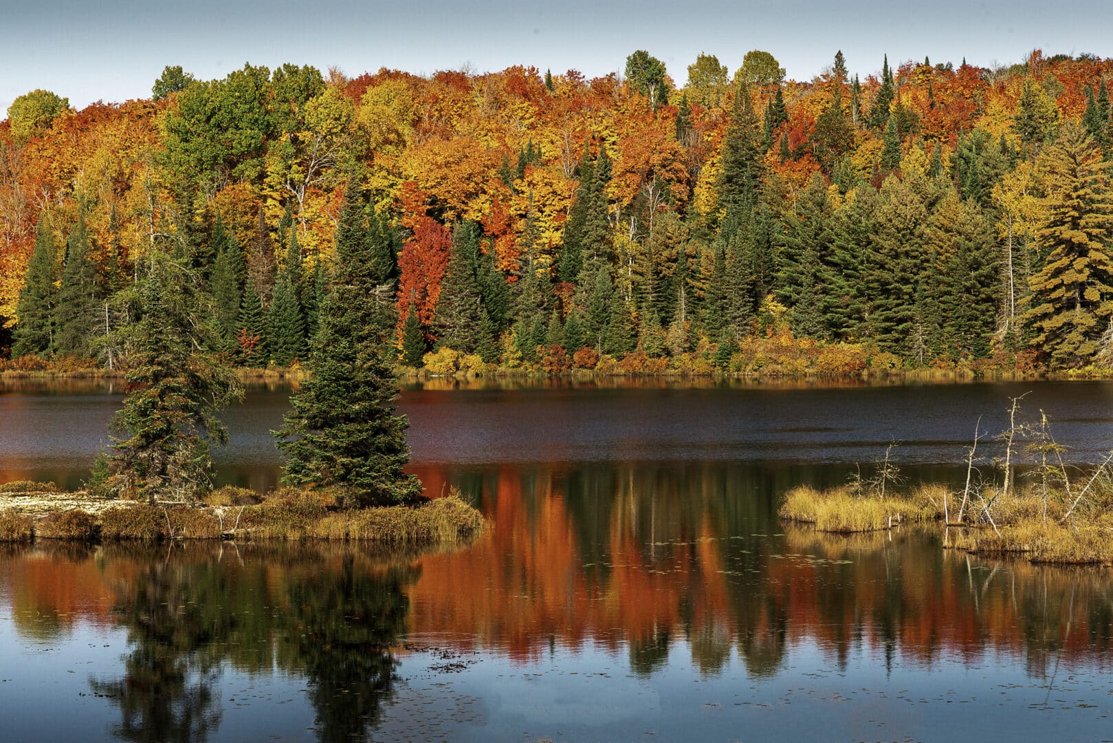 Beautiful fall foliage surrounding a peaceful lake.