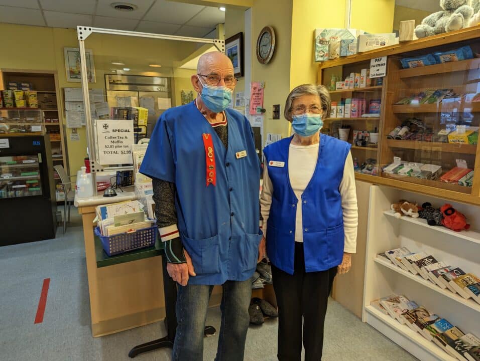 Volunteers, Jim and Elda Sopha, standing together in the Tuck Shop.