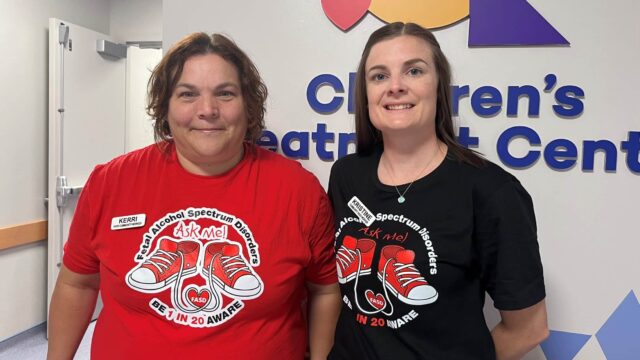 Two women wear t-shirts featuring red Converse shoes for FASD awareness month.
